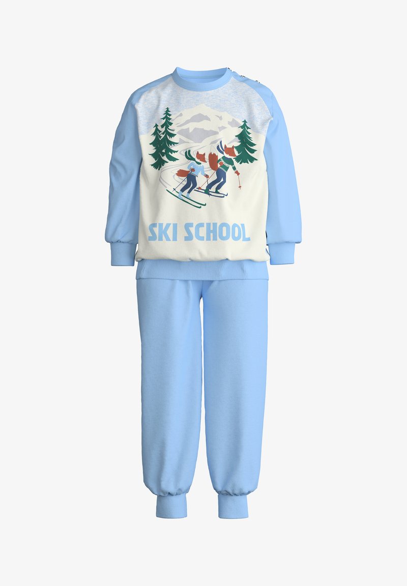 Luchtblauwe sweatpants en bijpassend crewneck met een grafisch ontwerp van skiërs, bomen en bergen met de tekst "SKI SCHOOL" in vet blauw. Zachte stof.
