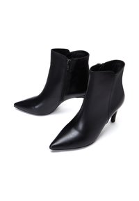 Bottines en cuir noir avec des pointes effilées et une fermeture éclair sur le côté. Présente une silhouette élégante et un talon aiguille de 5 à 7,5 cm. Texture lisse.