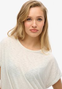 Lichtgrijze, korte mouwen t-shirt van een zachte, gestructureerde stof met een ronde halslijn en een subtiele kleurvariatie door het geheel.