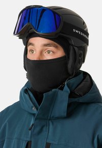 Zwarte skihelmo met blauwe spiegelende skibril, zwarte fleece nekwarmer en teal jas met ritsen en kraag. Duidelijk, functioneel ontwerp.