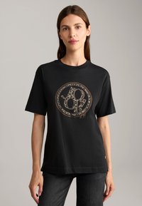 Zwarte katoenen t-shirt met een ronde, dierenprint logoontwerp in goud. Korte mouwen en een losse pasvorm. Eenvoudige halslijn en zoom.