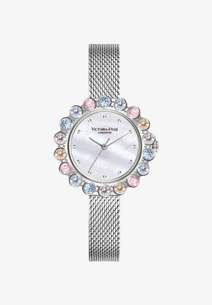 Zilveren gaasarmband horloge met een ronde, parelmoeren wijzerplaat omringd door kleurrijke kristallen in verschillende maten en kleuren. Merkennaam weergegeven.