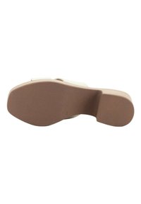 Suela de sandalia blanca con una suela de goma beige texturizada, que presenta un tacón ligeramente elevado y una superficie lisa para la tracción.