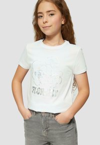 Biely tričko s krátkym rukávom s lesklým kvetinovým dizajnom a slovom "FLOWERY" v reflexných písmenách, v kombinácii so šedými džínsy.