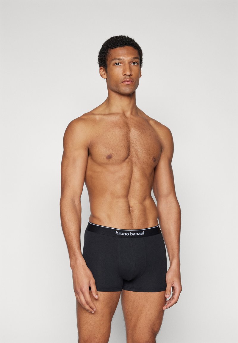 Boxer-briefs en coton noir avec une taille élastique marquée en blanc. La coupe est ajustée, avec une texture lisse et sans motifs visibles.