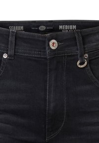 Jeans de denim oscuro con un diseño ajustado. Presentan un cierre de botón con un acento de metal y detalles de costura sutiles.