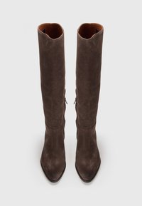 Bottes en daim marron, montantes jusqu'au genou, avec un bout pointu et une texture lisse. Dotées de deux fermetures éclair latérales pour un enfilage facile. Design simple et élégant.