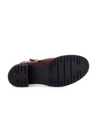 Botte en cuir brun avec une surface texturée, dotée d'une semelle en caoutchouc noir avec des rainures pour une meilleure adhérence et d'un logo de marque discret.