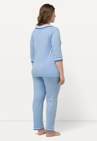 Conjunto de pijama azul claro con mangas de tres cuartos, cuello blanco en contraste y puños a rayas azules, con un ajuste relajado y una textura suave.