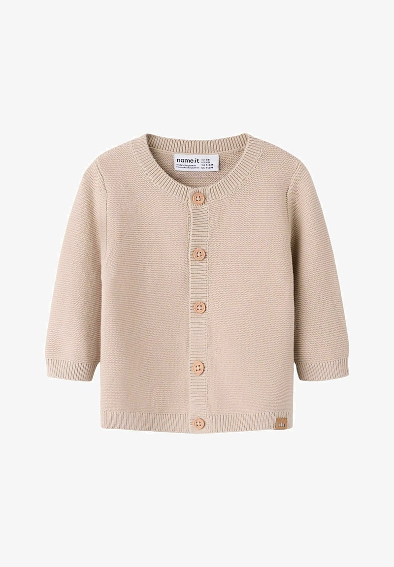 Beež kudumiga beebikardin pikkade varrukate, ümara kaelusega, ees viis puidust nööpi ning soonikkoes varrukakäärid ja alumine serv.