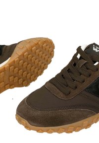 Brązowe buty sportowe z połączeniem gładkich i teksturowanych materiałów, sznurówki, oraz gumowa podeszwa z teksturowanym wzorem zapewniającym przyczepność.