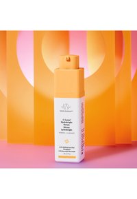 Drunk Elephant C-Luma Hydrabright Serum in a white and orange container, featuring a square top and pump dispenser. 30 ml size.