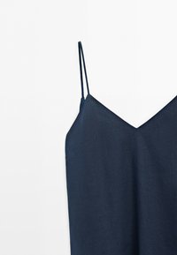 Robe bleu foncé sans manches avec fines bretelles spaghetti et décolleté en V sur fond blanc.