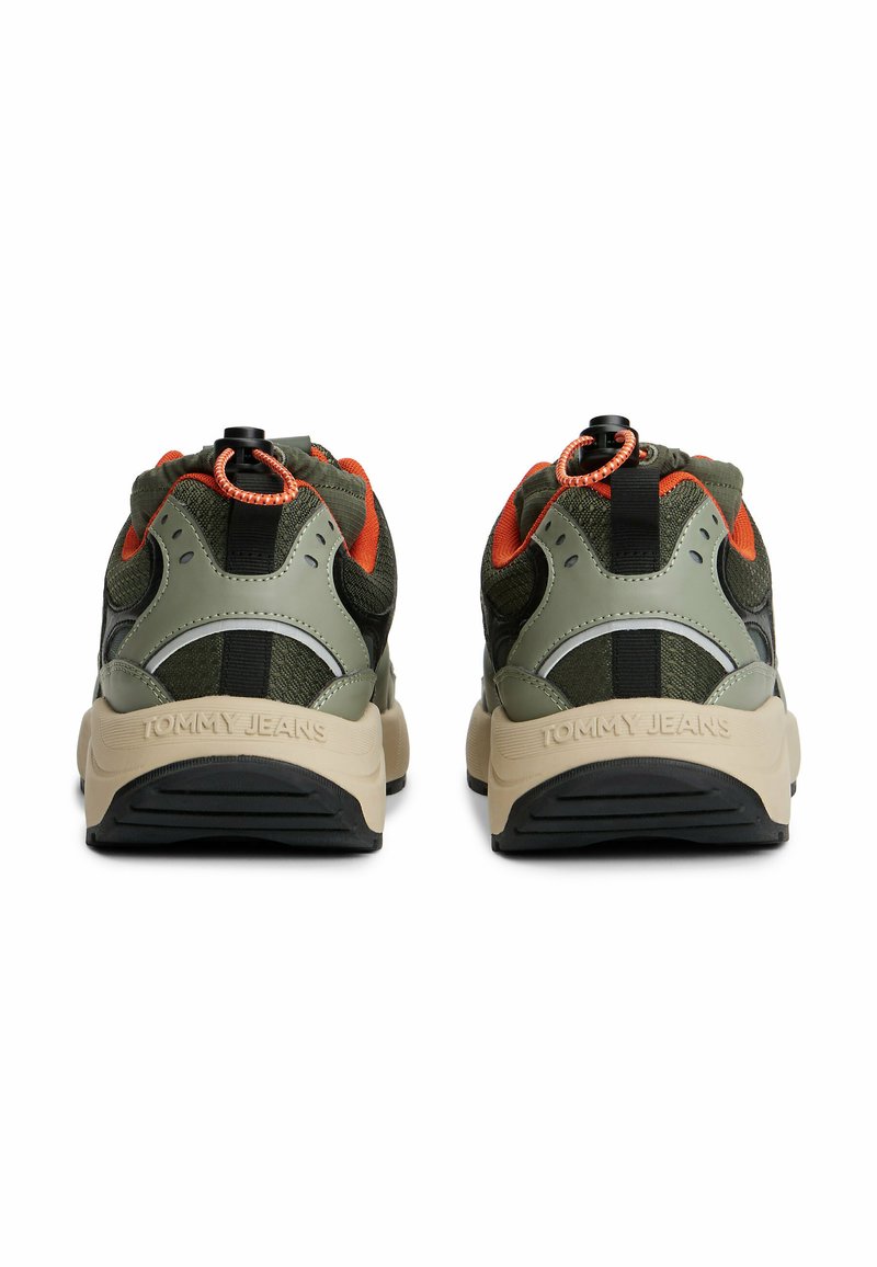 Green and black sneakers with a textured mesh upper, orange accents, and a rubber sole; features a toggle closure on the heel.