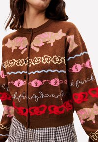 Bruine cardigan met roze katten, bloemen en theepotmotieven. Knopen aan de voorkant, met een kraag, textuurstof.