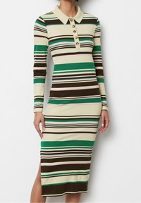 Sukienka midi z dzianiny w pionowe paski w odcieniach zieleni, brązu i kremu, z kołnierzykiem oraz zapięciem na guziki, a także z bocznym rozcięciem dla dodatkowego akcentu.