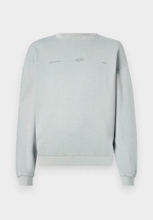 Jasnoniebieska bluza z długim rękawem, z prążkowanymi mankietami i dolną krawędzią, z delikatnym nadrukiem logo z przodu, wykonana z miękkiego materiału.