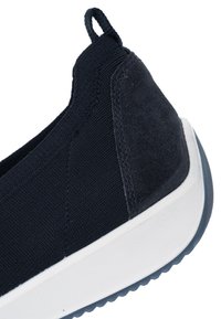 Marinblå slip-on-sko med en texturerad ovandel i tyg, en klack i mocka och en vit gummisula med ett mönstrat mönster.