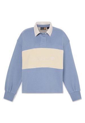 Camiseta polo de manga larga azul claro con una franja horizontal crema. Presenta el logo bordado de "Timberland" y un cuello de contraste.