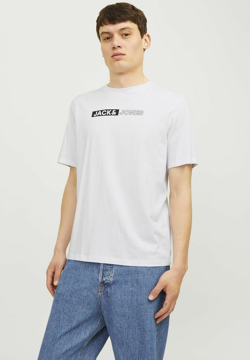Witte katoenen t-shirt met korte mouwen, voorzien van het "JACK & JONES" logo in zwarte print over de borst. Casual fit en een gladde textuur.