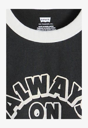 Schwarzes Levi's T-Shirt mit weißem Kragen und großem weißen Umrisstext "ALWAYS ON" auf der Vorderseite, Etikett zeigt Herstellung in Bangladesch an.