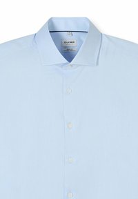 Hellblaues Herrenhemd mit ausgestelltem Kragen, weißen Knöpfen vorne und "OLYMP" Markenschild innen am Kragen.