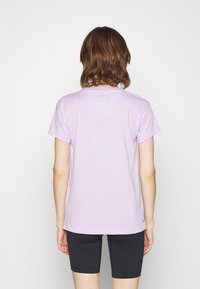 Lavender short-sleeve t-shirt with a crew neckline and a relaxed fit, paired with black bike shorts, featuring smooth cotton fabric.