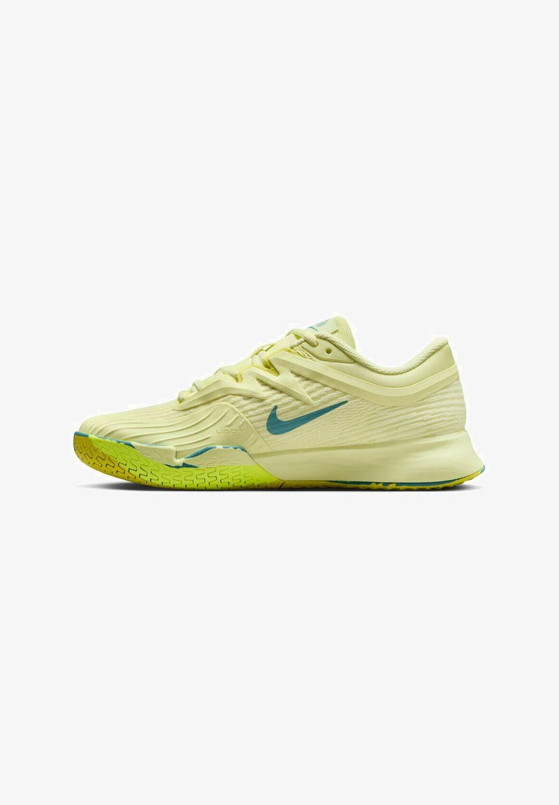 Zapatilla de running de color amarillo claro con acentos azules. Parte superior texturizada, mediasuela acolchada y suela de goma con detalles verdes. Diseño con cordones.