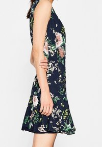Květinové šaty v námořnické modři, bez rukávů, s živými růžovými a zelenými květinami, založený lem, texturovaná látka.