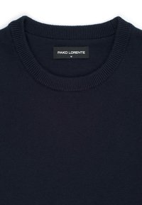 Ciemnogranatowy dzianinowy sweter z okrągłym dekoltem. Charakteryzuje się teksturowaną powierzchnią oraz metką z napisem "PAKO LORENTE" w białym kolorze na czarnym tle.