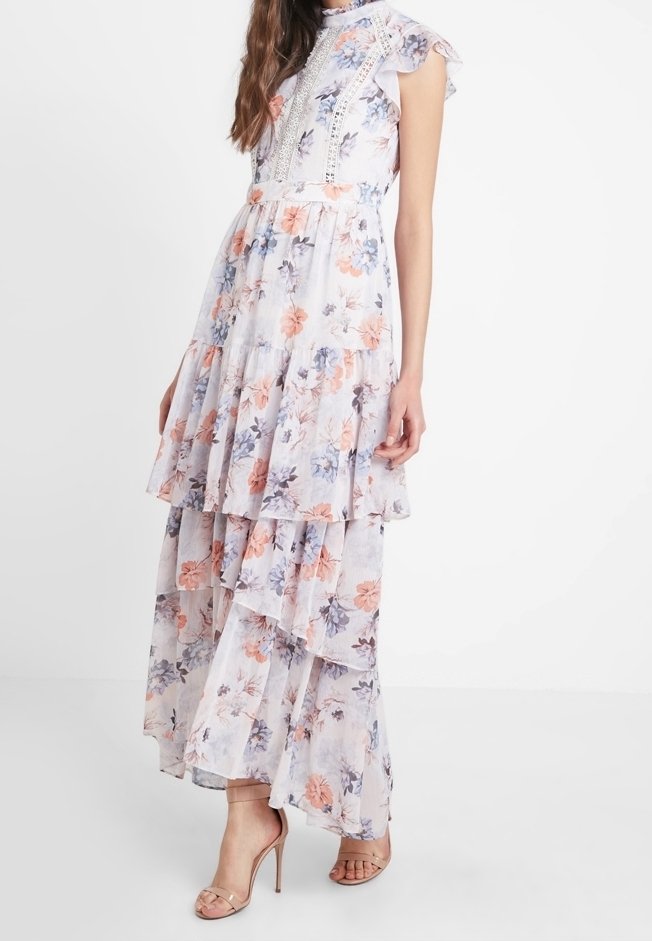 Robe longue fleurie en tissu léger avec manches volantées, couches multiples et dentelle délicate. Couleurs comprenant un rose doux et un bleu.
