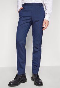 Tailored blue dress pants with a smooth texture, straight leg design, and belt loops, paired with black leather dress shoes.