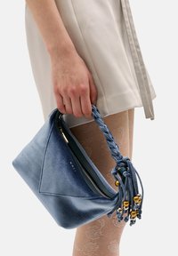 Borsa in suede blu con manico intrecciato, perline dorate e forma triangolare. Chiusura con zip superiormente per un facile accesso.
