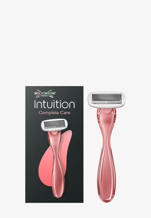 Scheermes van Wilkinson Sword Intuition Complete Care met roze handvat en een kop met vier mesjes, naast de donkere verpakking met roze accenten.