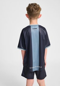 Marineblå och ljusblå kortärmad sporttröja med vertikala ränder och texten "INTERNATIONALS" vid fållen. Lättviktsmaterial, avslappnad passform.