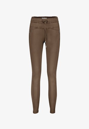 Brune sweatpants lavet af et strækbart materiale, med elastisk talje og snor. Har sidelommer med lynlås og kontrasterende sømdetaljer.