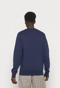 Felpa blu navy con maniche lunghe, polsi e orlo a coste, realizzata in materiale morbido, con un semplice design a girocollo.