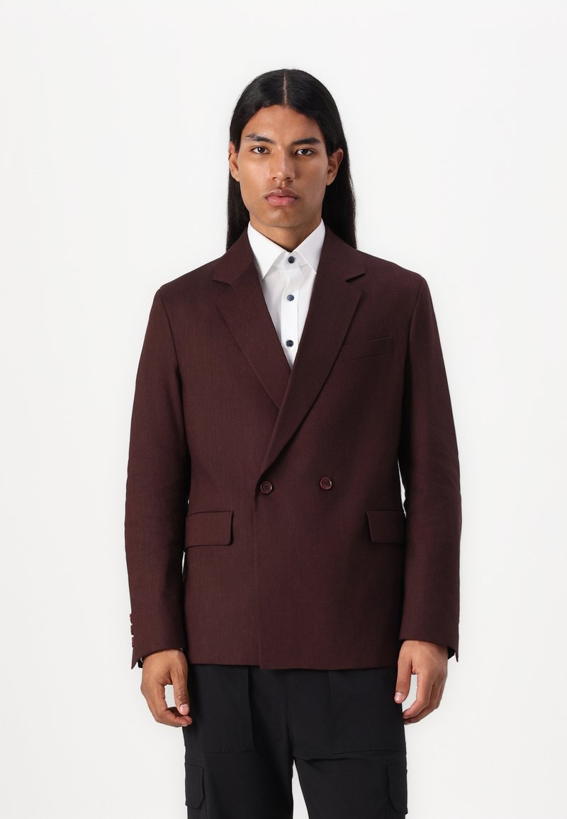 Burgundy dubbelknäppt kavaj, texturerad tyg, slagkragar, framfickor, bärs över en vit skjorta med blå knappar, slim fit-design.