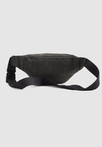 Schwarze Stofftasche mit verstellbarem Gurt und Schnappverschluss aus Kunststoff, vor einem schlichten hellen Hintergrund gezeigt.