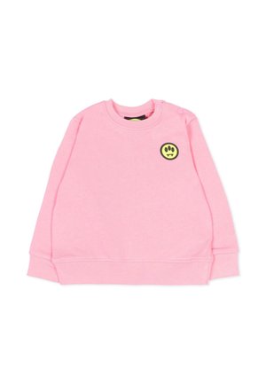Roze sweater met lange mouwen en een ronde hals, met een kleine gele en zwarte smiley-patch op de bovenste linkerborst en drukknoopjes op de schouder.
