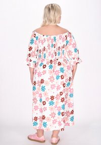 Maximekle med avtagbar skuldre nakkekant, blomstermønster i rosa, blå og brun, smocked liv og lagdelte volangermuffer.