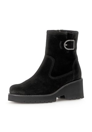 Zwarte suède enkelboot met een ronde neus, chunky hak, zilveren gesp-accent en contrasterende stiksels aan de zijkanten. Geverfd rubberen zool.