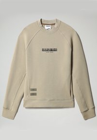 Sudadera beige con cuello redondo acanalado, mangas raglán y logo en el frente. Los acentos laterales incluyen etiquetas rectangulares con texto. Textura suave.