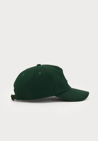 Grønn bomulls baseballcaps med buet skjerm, justerbar stropp bak og broderte detaljer på toppen. Enkel design.