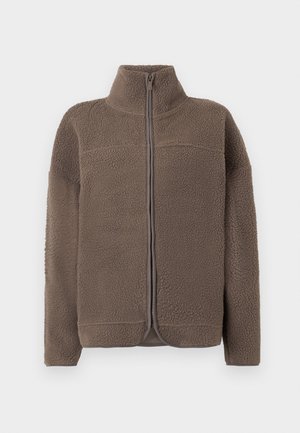 Ruskea fleece-takki, jossa on korkea kaulus, vetoketjusuljenta ja teksturoitu pinta. Ominaisuuksiin kuuluu pitkät hihat ja rento leikkaus.