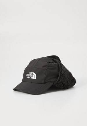Casquette noire avec un doublure douce et duveteuse sur les pattes d'oreilles. Présente une visière structurée et un logo blanc à l'avant. Matériau résistant aux intempéries.