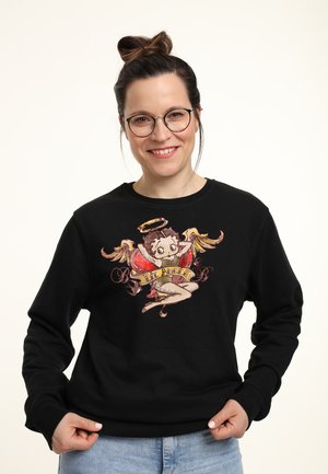 Černá mikina se vyšitým motivem dívky v stylu pin-up s andělskými křídly, svatozáří a bannerem "Lil' Angel" v růžových a zlatých akcenty.