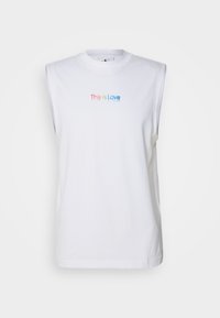 Camiseta sin mangas blanca de algodón con cuello redondo. Presenta un texto multicolor "Esto es Amor" en la parte delantera, con un diseño minimalista.