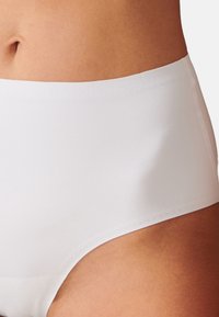Högmidjade vita bomullsbriefs med slät textur och elastisk midja, med sömlös design för komfort och diskret användning.