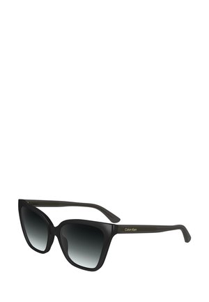 Occhiali da sole oversized neri con lenti a gradiente da scuro a chiaro, caratterizzati da una forma geometrica a occhio di gatto e dal marchio Calvin Klein sul lato.